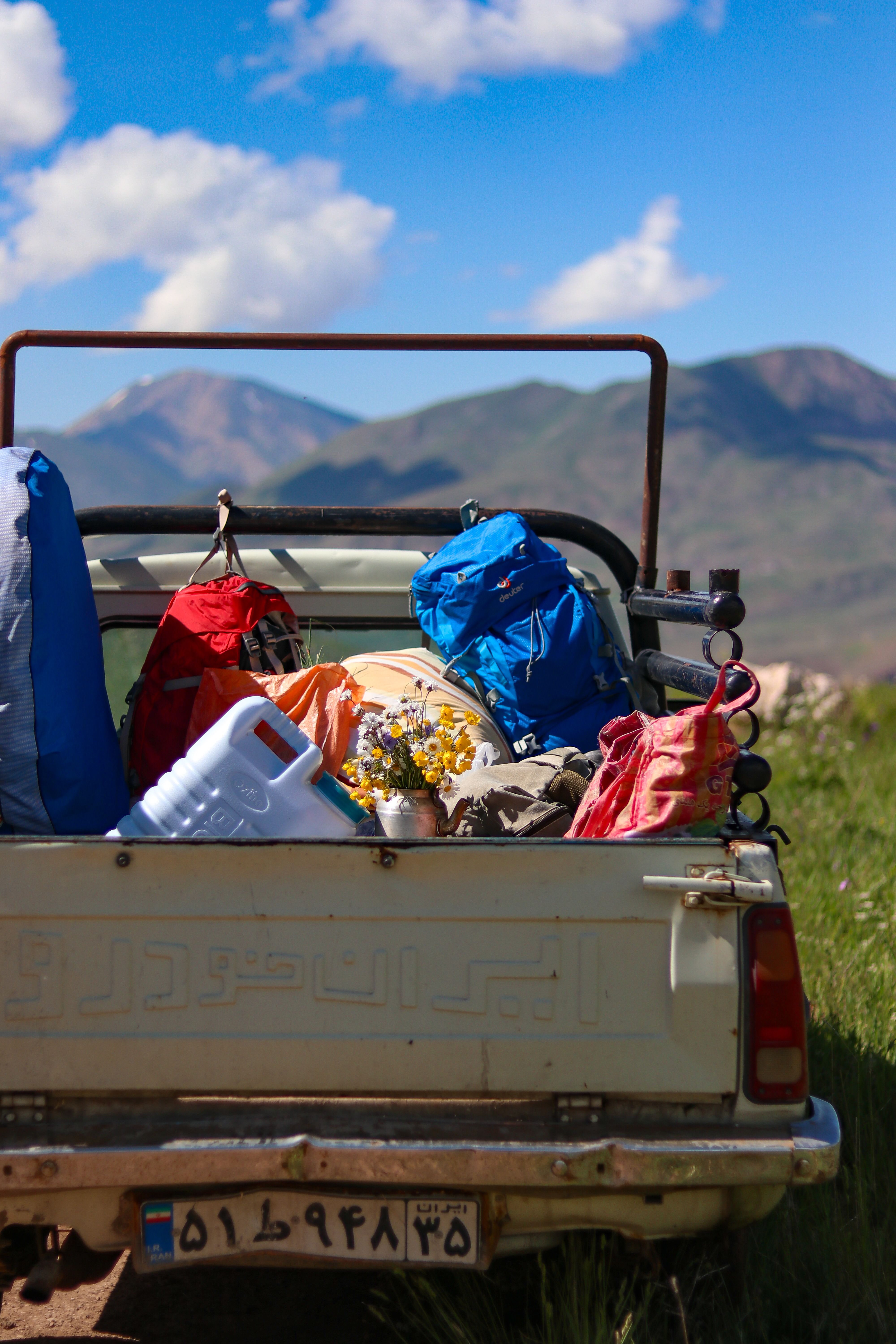 Pickup bed loaded with packs and gear against a mountain backdrop